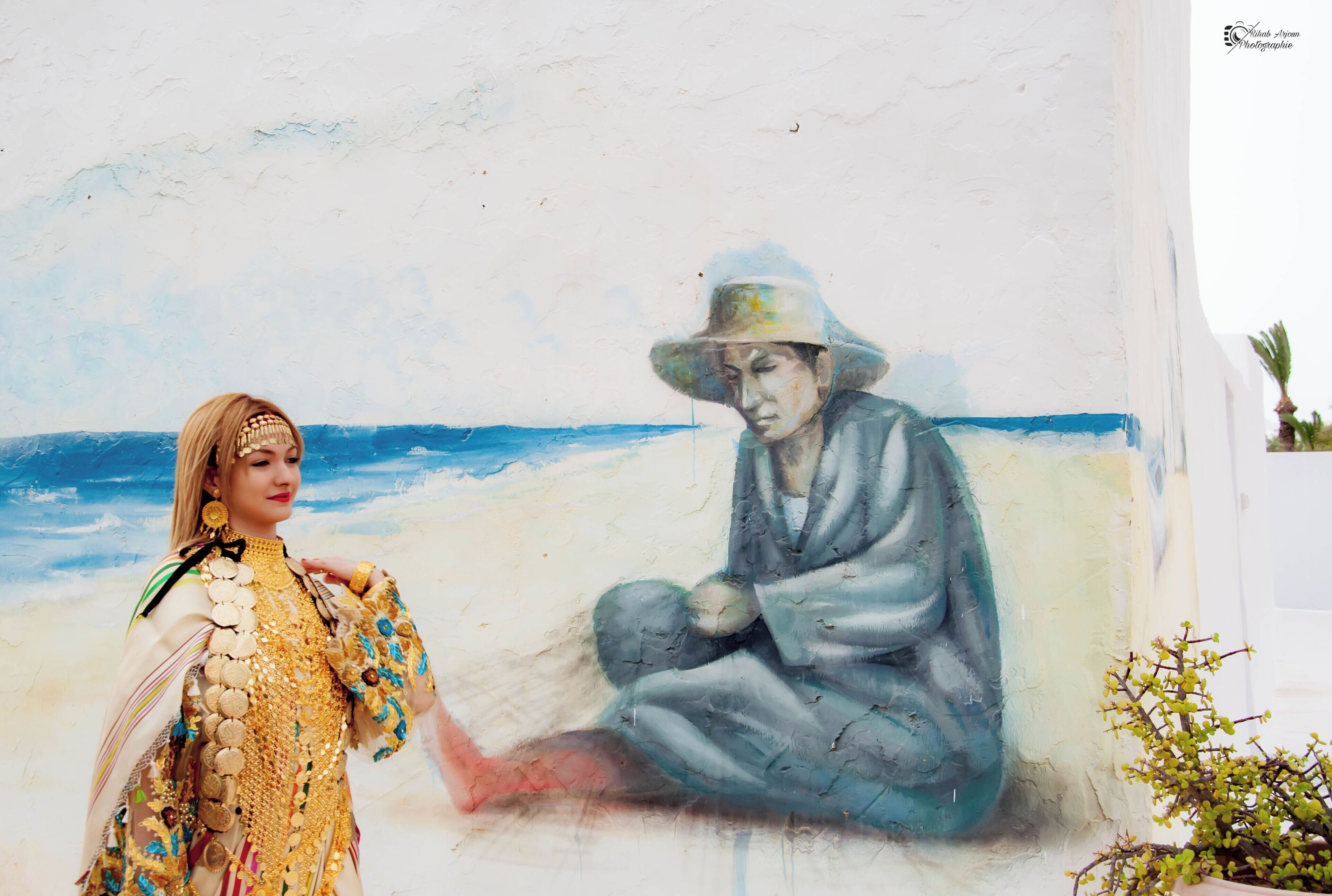 A mural of a person in traditional attire on a wall.