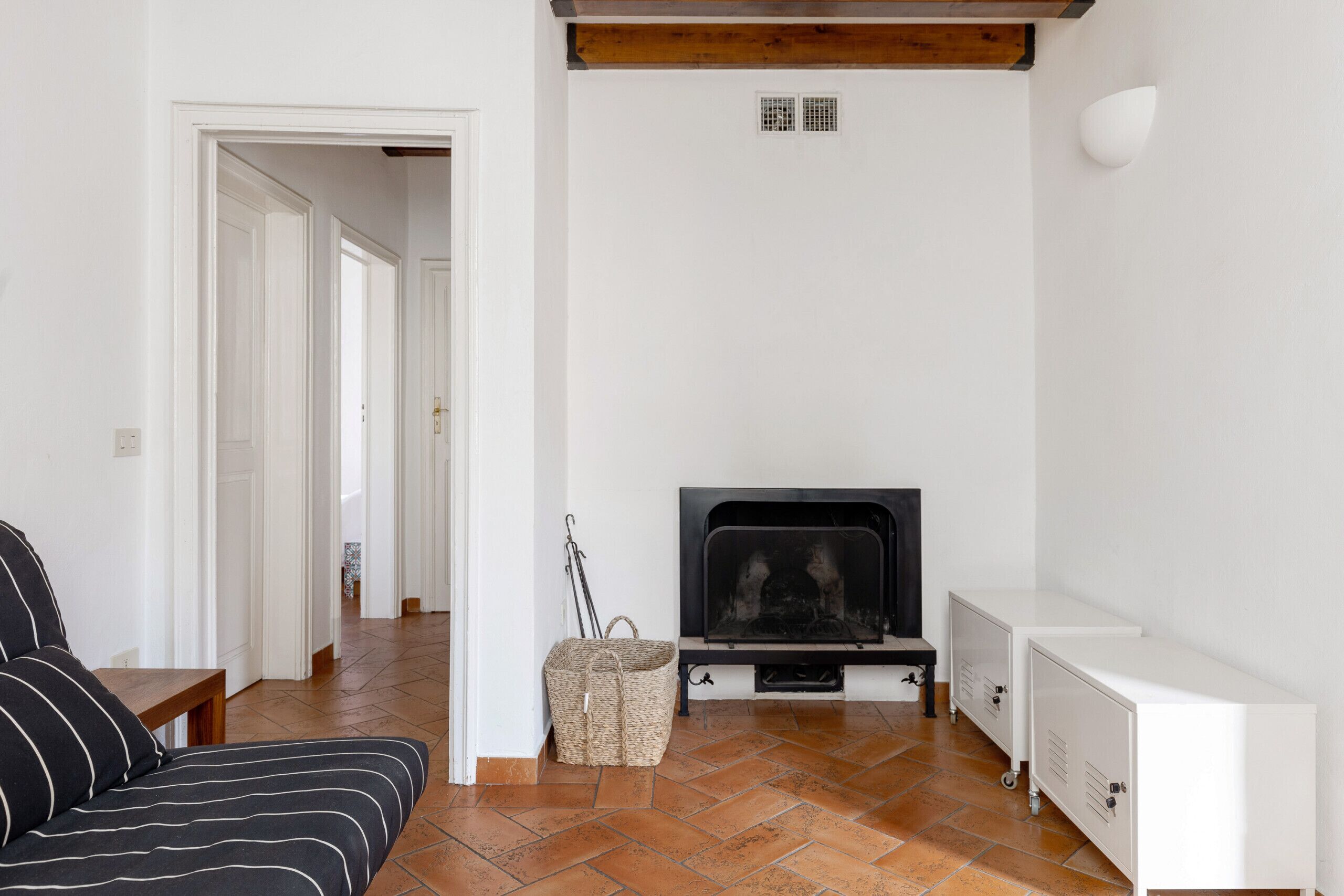 Un salon avec une cheminée, un canapé, un banc et une petite table.
