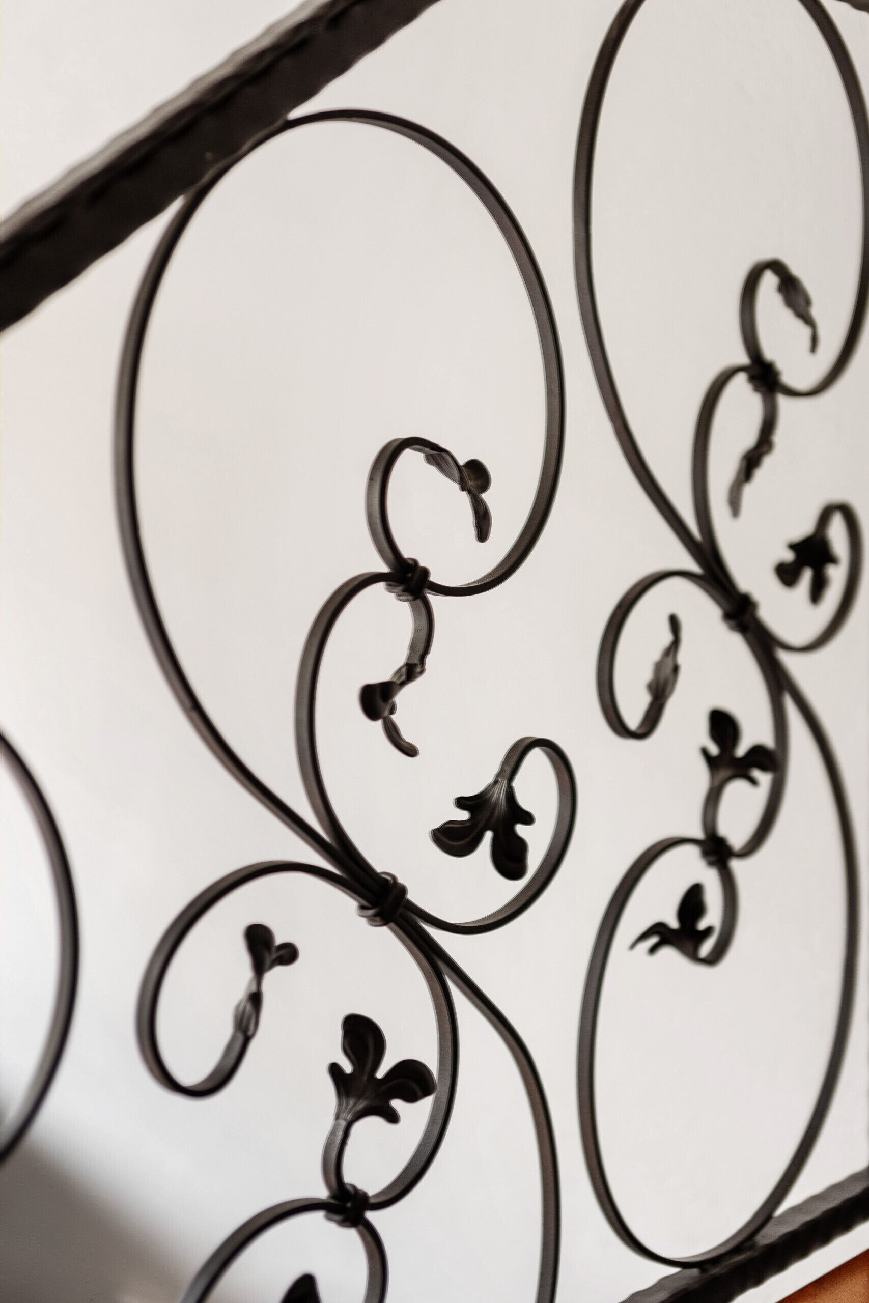 Un primo piano di una ringhiera in metallo con elaborate decorazioni a volute.