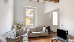 Ein Wohnzimmer mit einer Couch, einem Fernseher und einem Couchtisch.