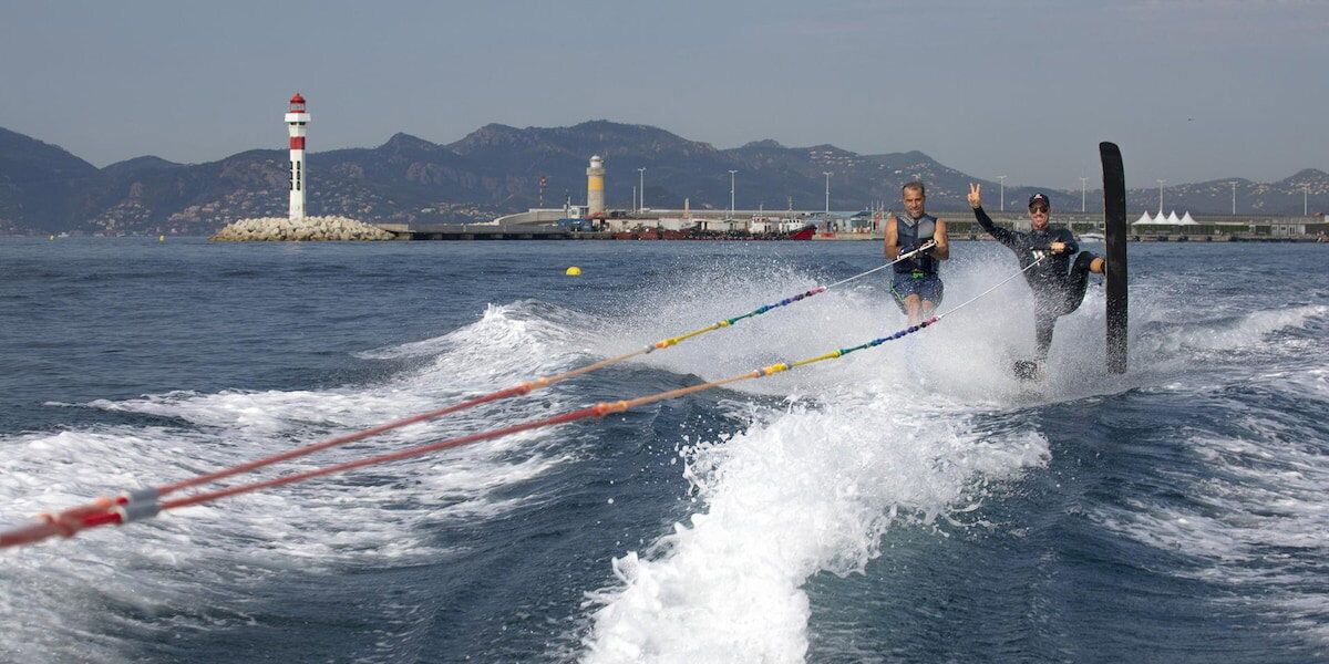 A water sport activity with a lighthouse in the background.