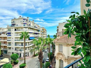 A coastal urban area with multi-story buildings, palm trees, and a clear sky.