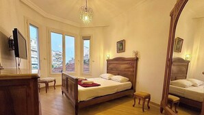 Une chambre à coucher avec un lit en bois, une commode, un miroir et un téléviseur.
