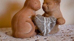 Deux statuettes d’ours en terre cuite, posées sur une surface texturée.