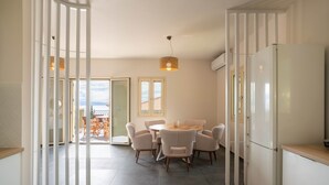 A modern kitchen with a dining area, white cabinetry, and a large refrigerator. - The Cerulean Villa - The Concord Of Blue And Green! (Kefalonia)