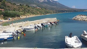 A marina with boats docked, a rocky shoreline, and a mountainous backdrop. - The Cerulean Villa - The Concord Of Blue And Green! (Kefalonia)