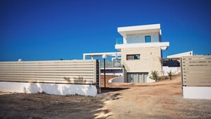 A modern house with a prominent entrance, a small balcony, and a clear sky. - Starlight Villas-8bd, Available For Events (Rethymno)