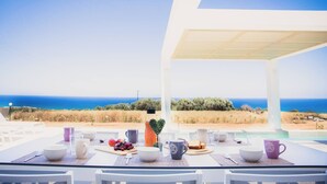 A table set for breakfast with a view of the sea and a white building structure. - Starlight Villas-8bd, Available For Events (Rethymno)