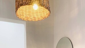 A bathroom with a modern design, featuring a large mirror, a white sink, and a wicker light fixture. - Small Hidden Spot In La Veleta (Tulum)