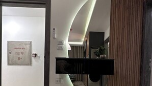 Un interno moderno caratterizzato da una parete curva, un arrotolatore di tubo antincendio e un pannello in legno.