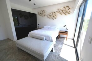 A modern bedroom with a large bed, a bench, a desk, and a decorative wall piece. - Bh 07 - Penthouse Glamorous Zen In The Jungle (Tulum)