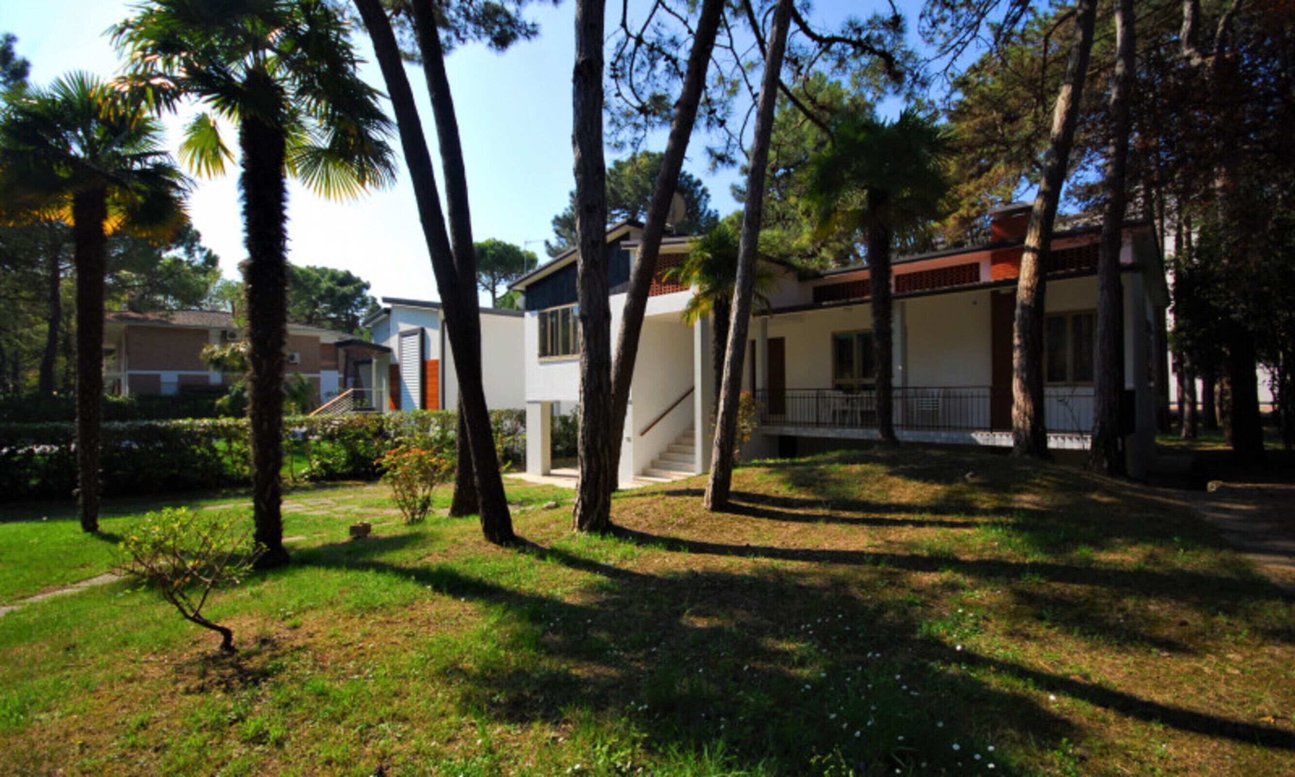 Zona residencial con casas modernas, un césped cuidado y un cielo despejado.