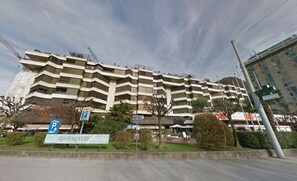 En byggnad med flera våningar, en skylt som visar var man kan parkera, en restaurangskylt och en klar himmel.