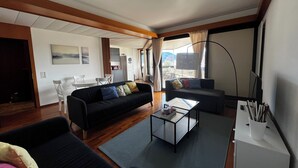 Un salon moderne comprenant un canapé, une table basse et un coin repas avec des chaises et une table.