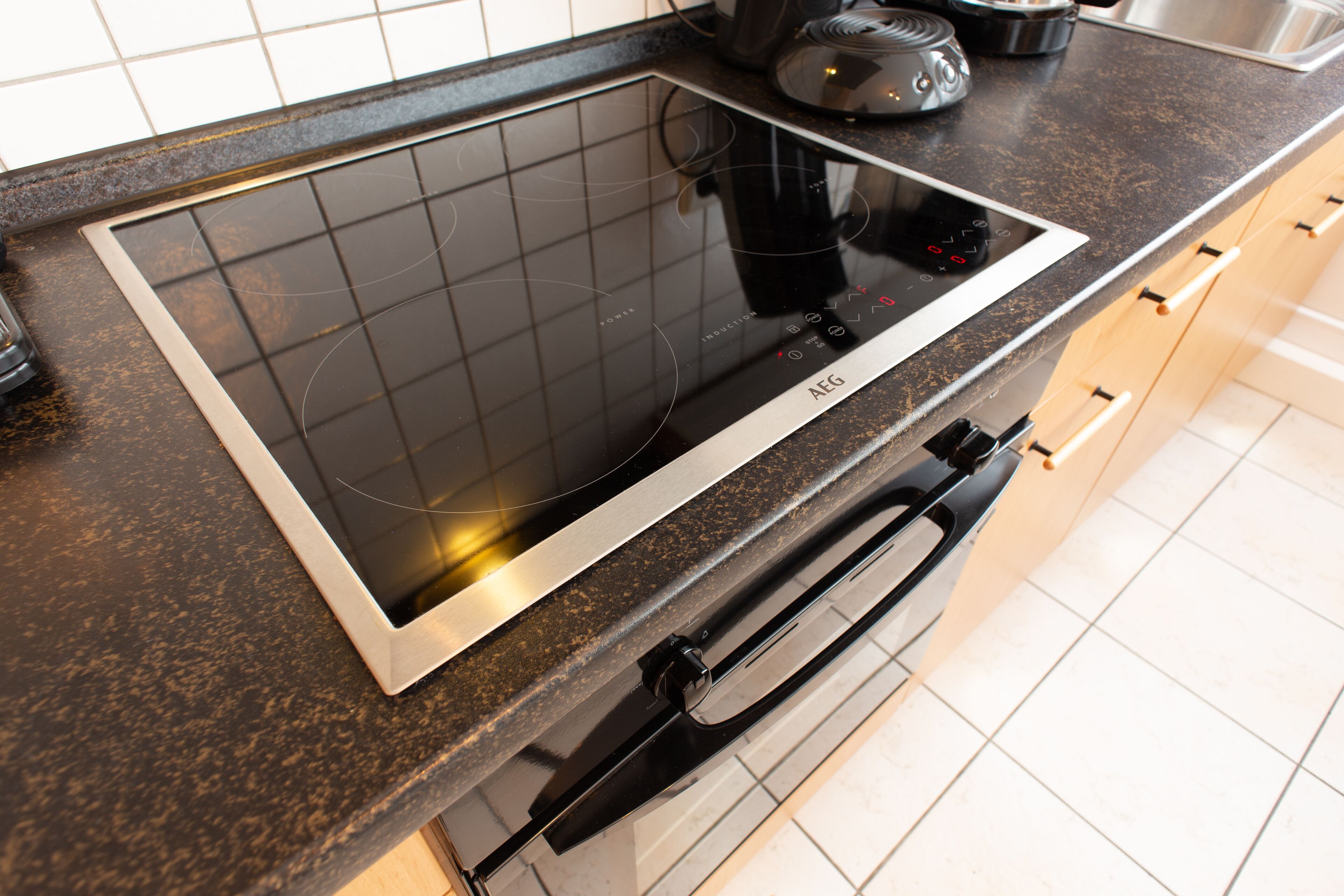 Uma cozinha com fogão por indução embutido e máquina de lavar louça.