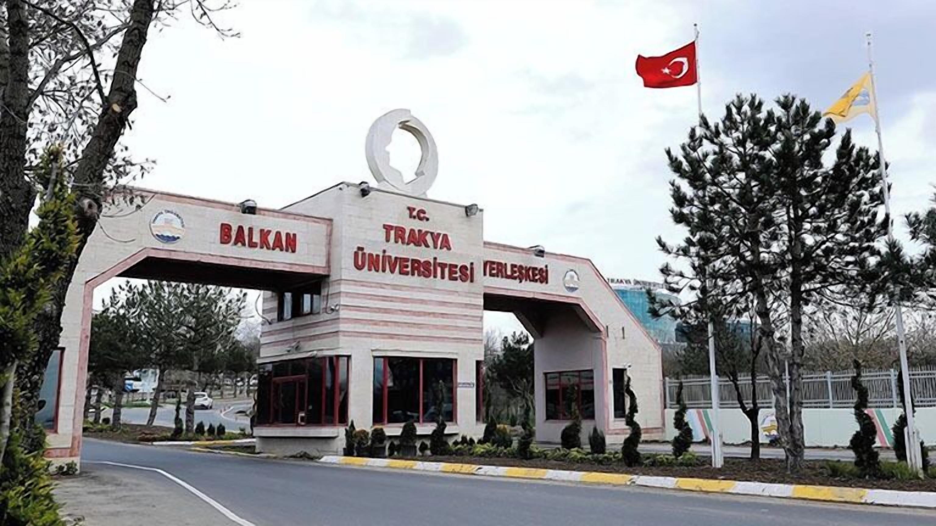 The entrance to a university with a prominent archway and flags.
