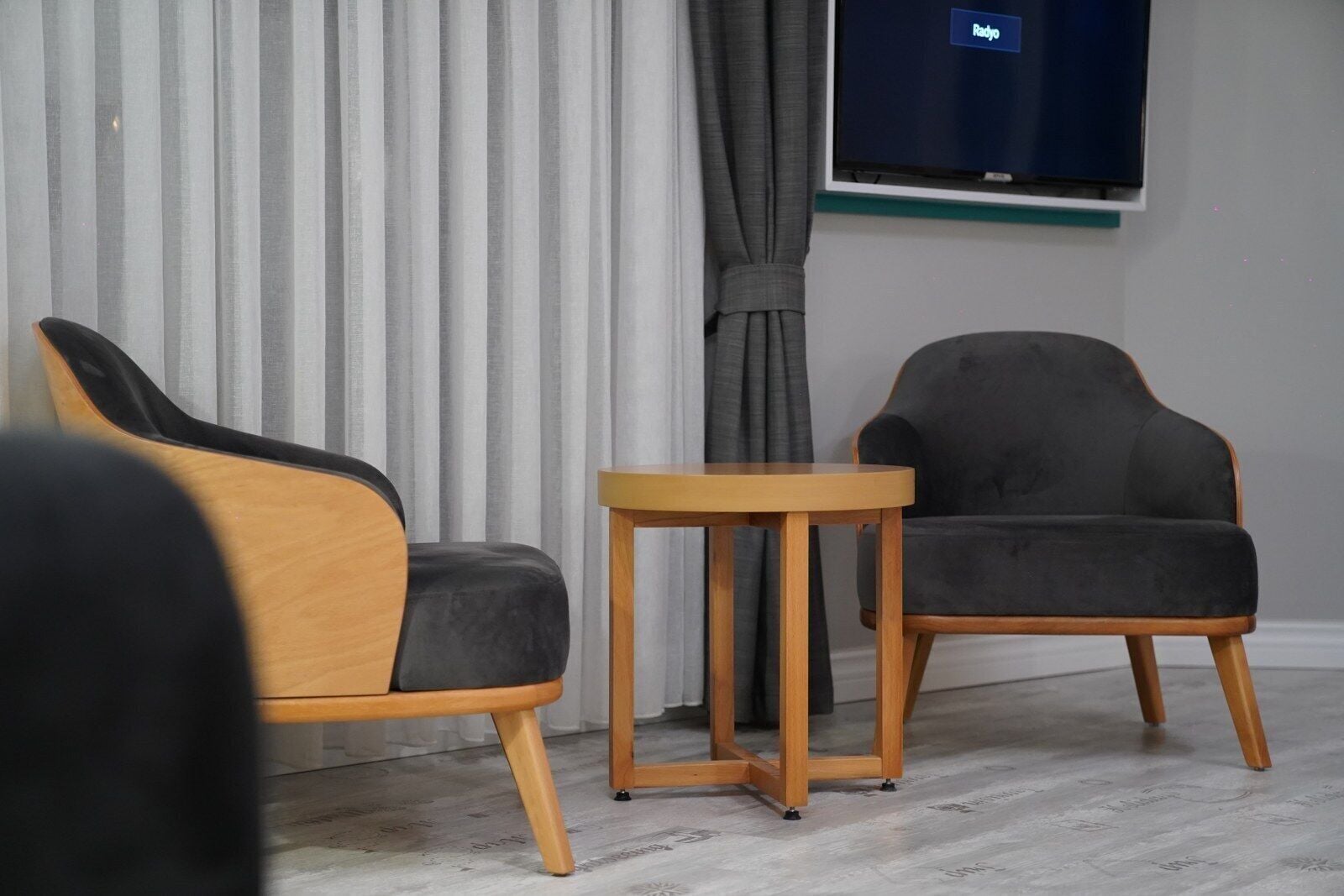 Una sala de estar moderna con dos sillones y una pequeña mesa de madera.