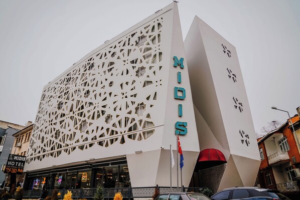Un edificio moderno con fachada geométrica y el nombre "MIDIS" exhibido en grande.