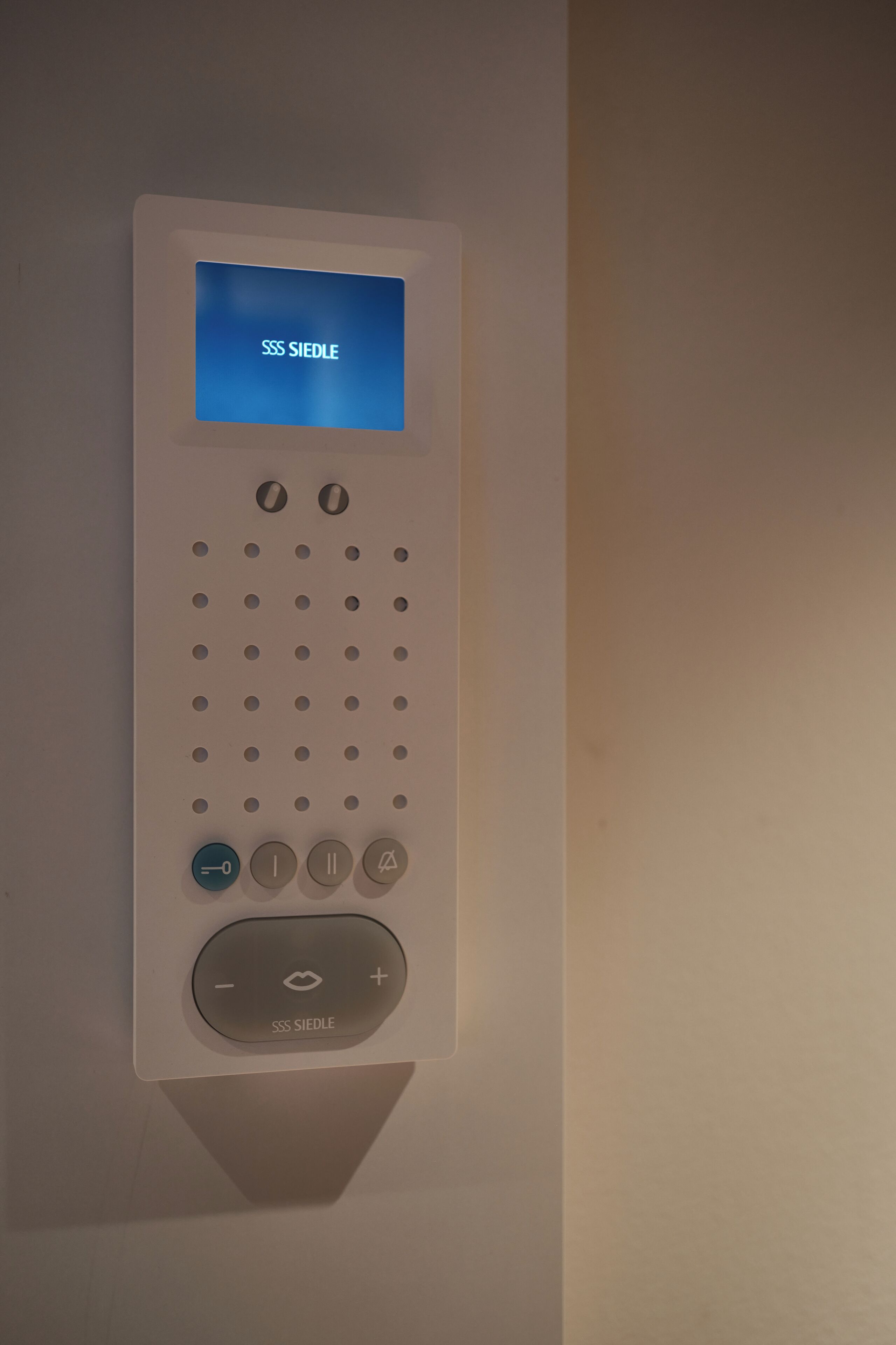 Un panel de control fijado a la pared, con pantalla digital y varios botones.