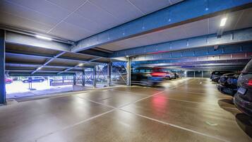 An underground parking garage with multiple levels, concrete floors, and metal beams.