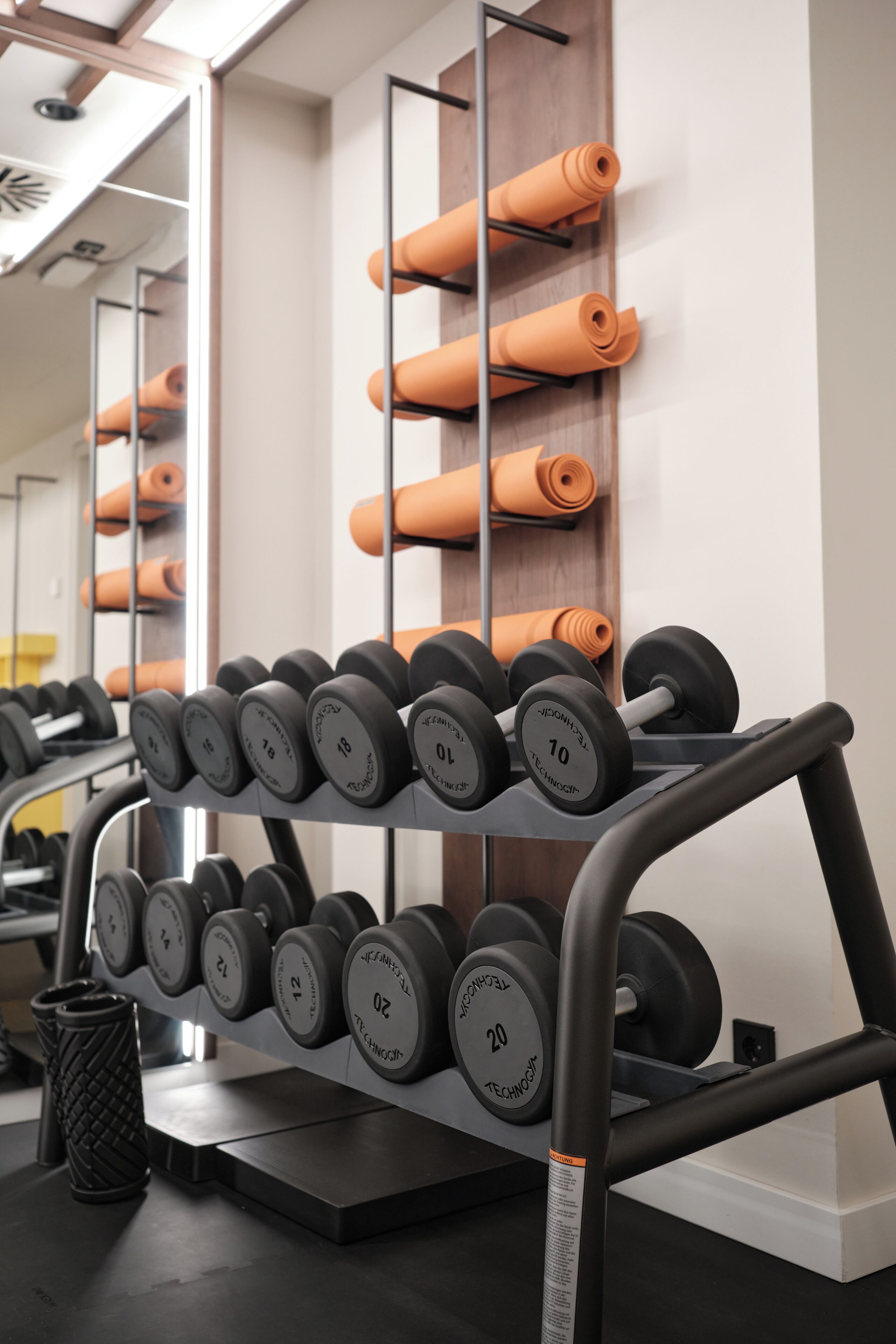 A gym with a rack of dumbbells and yoga mats.