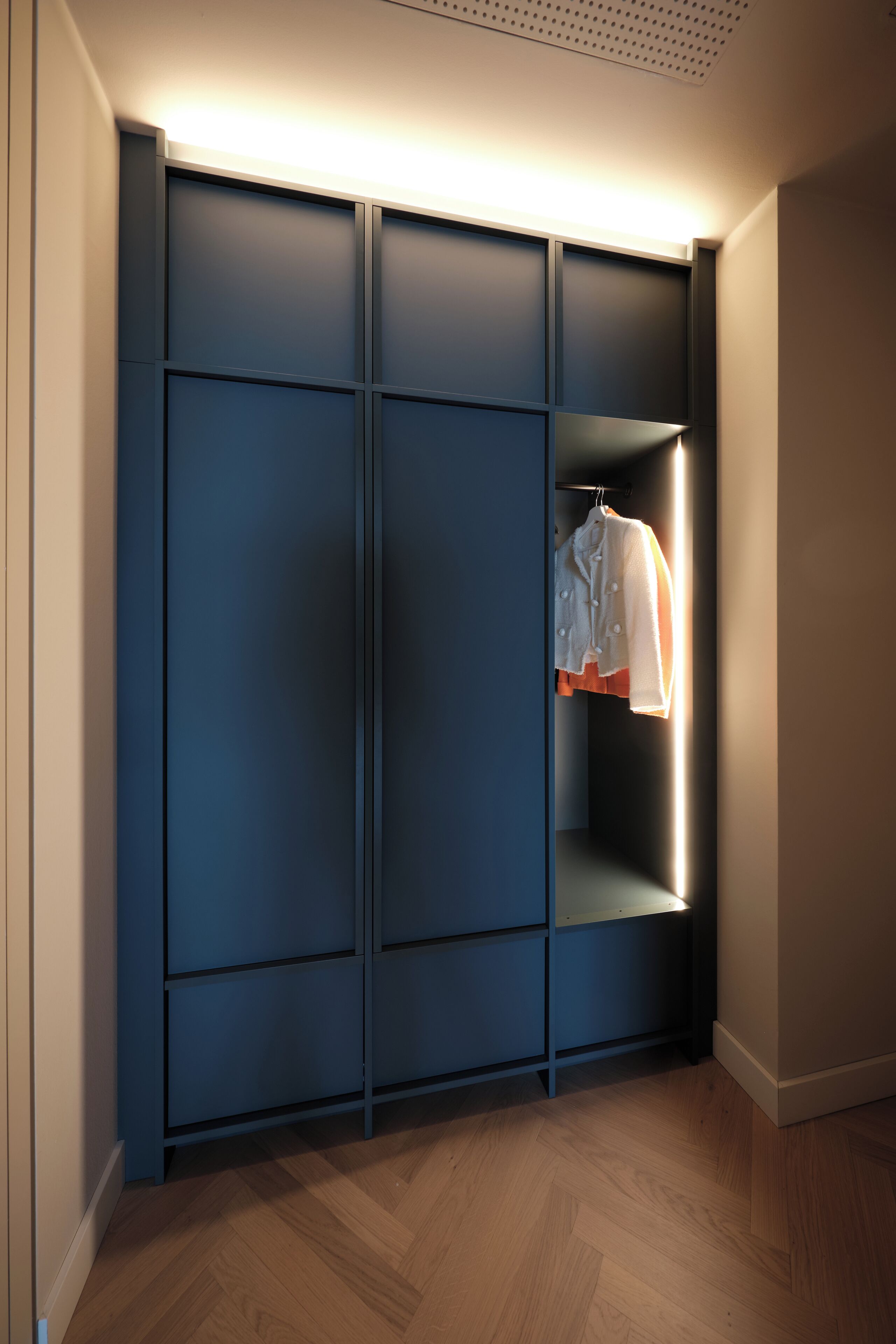 A modern closet with sliding doors and a hanging rack.