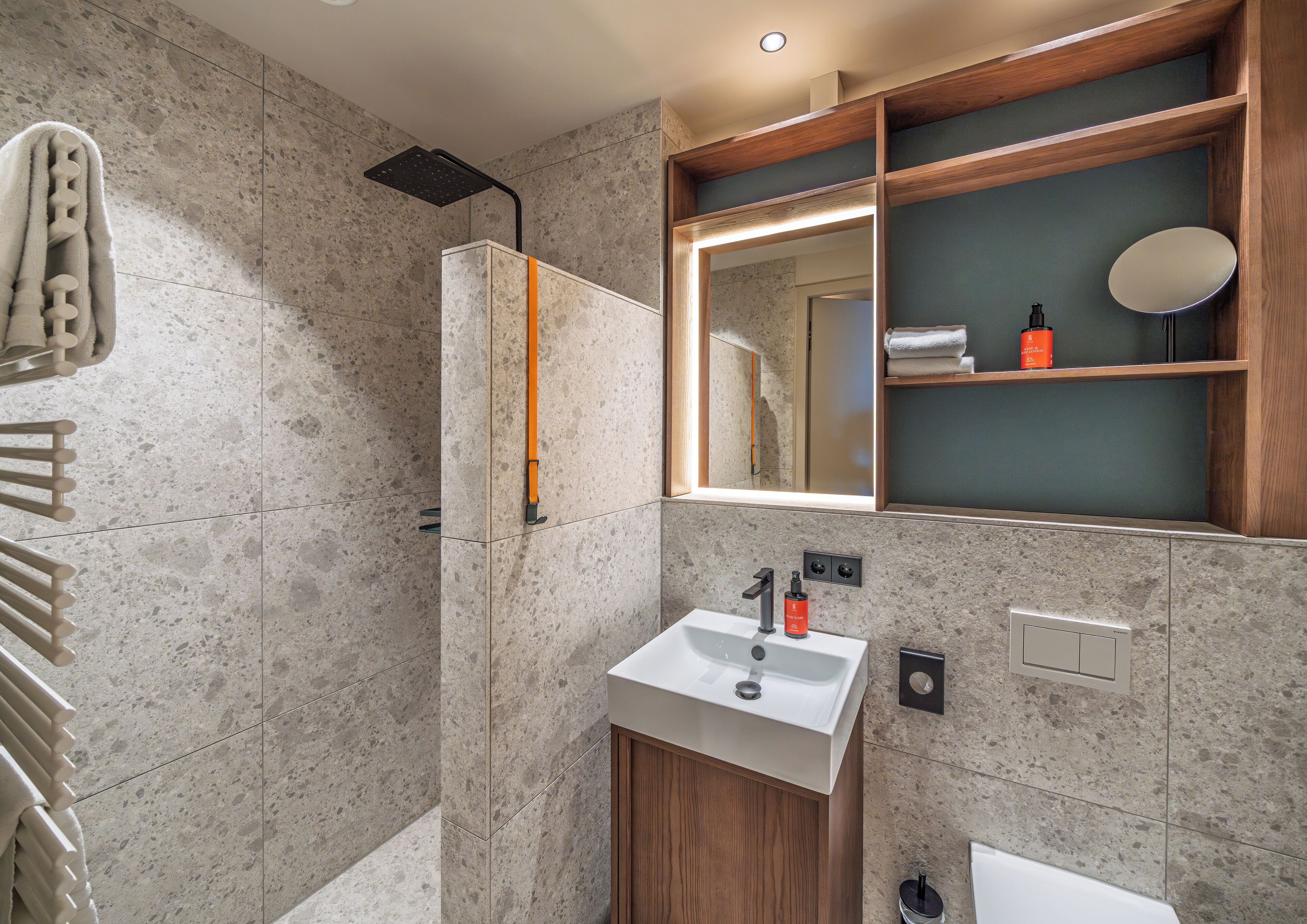 Une salle de bain moderne équipée d’une douche, d’un lavabo et d’un miroir.