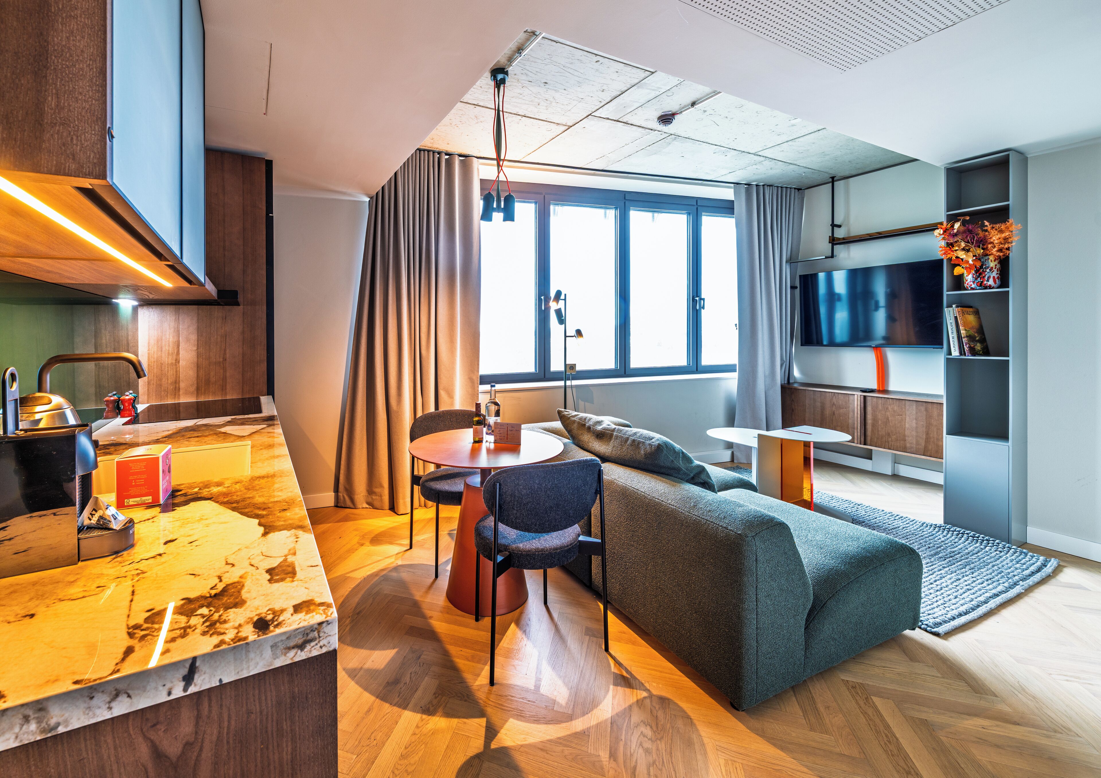 Una sala de estar moderna con un sofá, una mesa de comedor y un televisor.