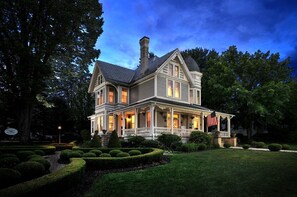 A large, two-story house with a wrap-around porch and a flag. - Historic Inn located 2 miles from New River Gorge National Park (Fayetteville)