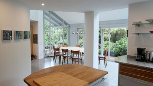 Cocina moderna con una mesa de madera, una cafetera y vistas a zonas verdes.