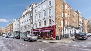 Um edifício de vários andares com restaurante no andar térreo e lojas adjacentes.