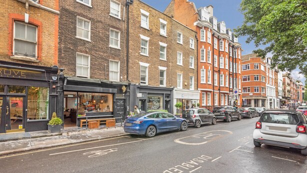A street with a row of buildings, including a shop with a sign that reads "Balance".