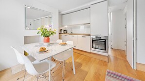 Eine moderne Küche mit weißen Schr änken, einer Marmorarbeitsplatte und einem eingebauten Backofen.