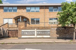 A two-story building with a brick facade, numbered '2' on the ground floor, and a sign reading 'COMPTON TERRACE' above the entrance.