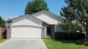 A single-story house with a garage, a front door, and a satellite dish.