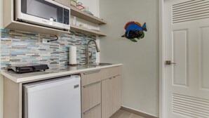 A compact kitchen with a microwave, sink, and a small refrigerator. - TBS 34A Studio-Garden View-Shared Pool-Beachfront (Placencia)