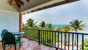 Ein Balkon mit Blick auf den Strand und Palmen.