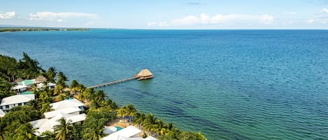 A tropical resort with overwater bungalows connected by a wooden dock.