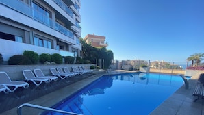 A swimming pool with lounge chairs and a stone deck. - Artplatinum Suites & Apartments (Benalmádena)