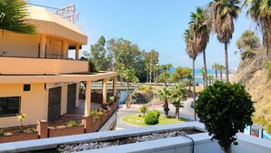 A building with a flat roof and a balcony, surrounded by palm trees and a clear sky. - Artplatinum Suites & Apartments (Benalmádena)