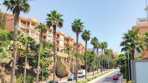 A street lined with palm trees and multi-story buildings with balconies. - Artplatinum Suites & Apartments (Benalmádena)