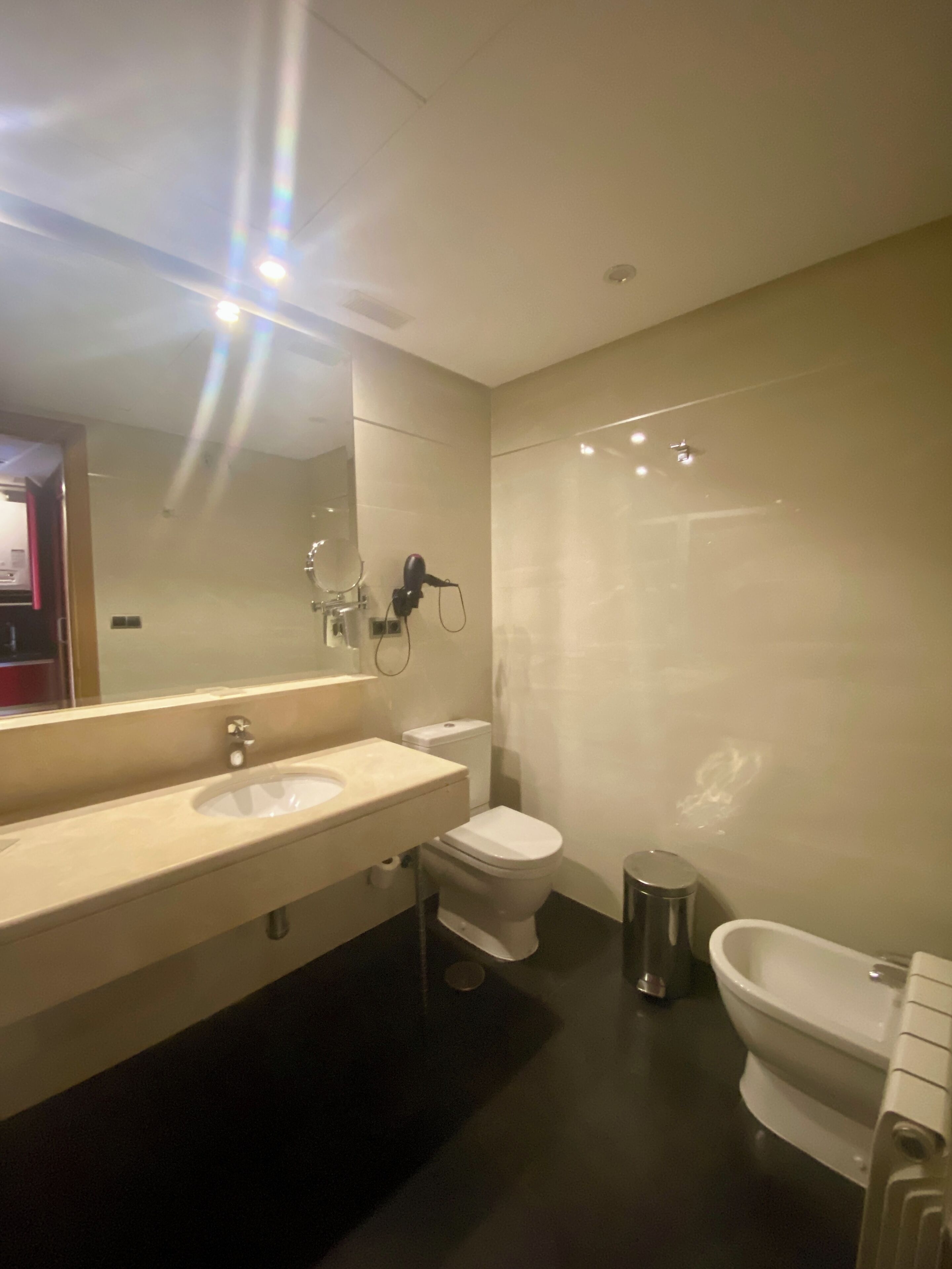 A modern bathroom with a double sink vanity, a toilet, and a bathtub.