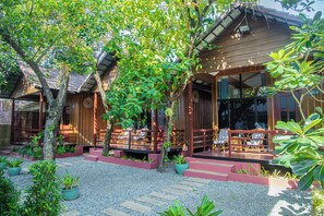 A traditional wooden house with a covered porch and outdoor seating area.
