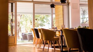 Uma área de refeições moderna com piso de madeira, uma mesa e cadeiras.