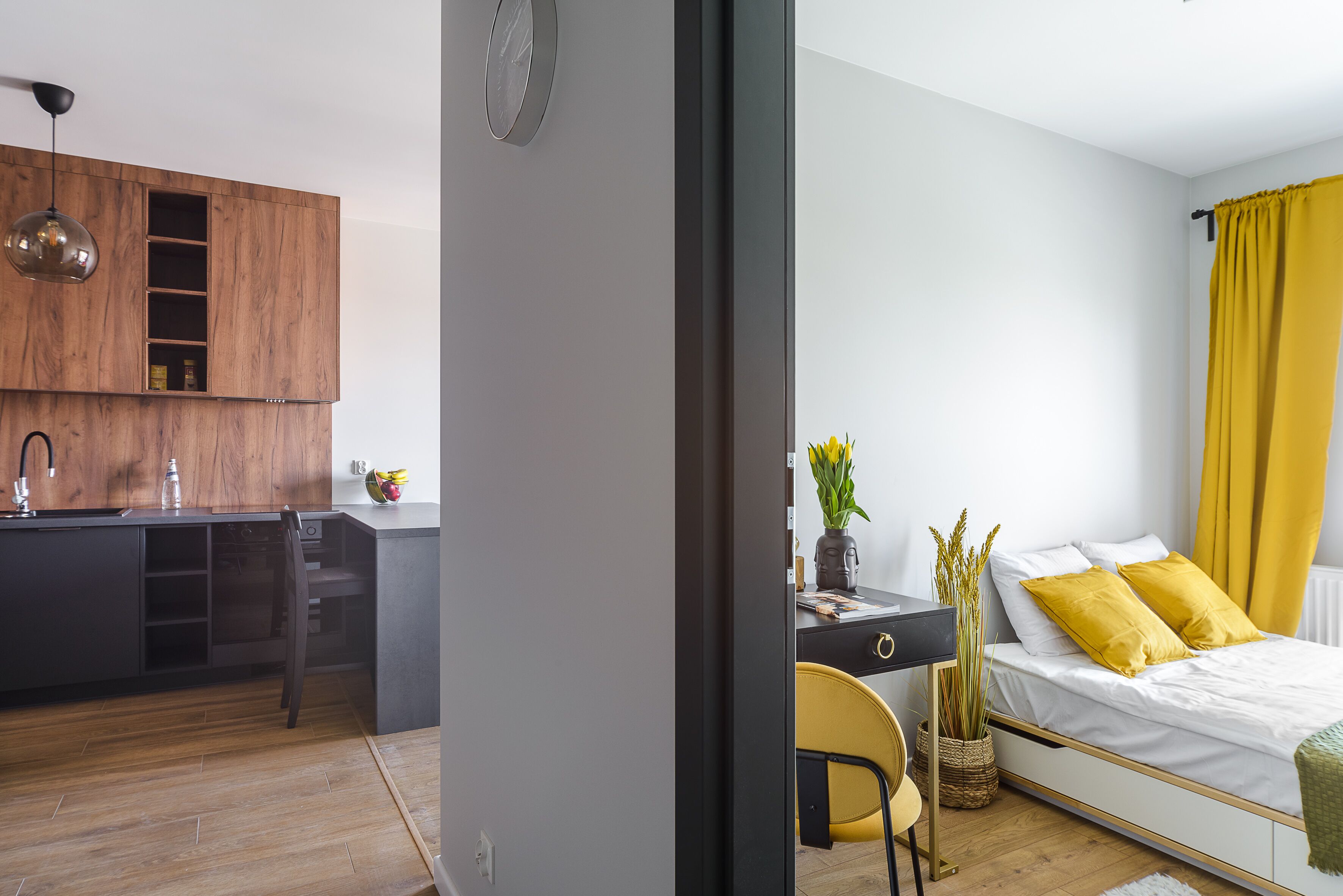 Une chambre moderne avec un lit, un bureau et un coin cuisine.