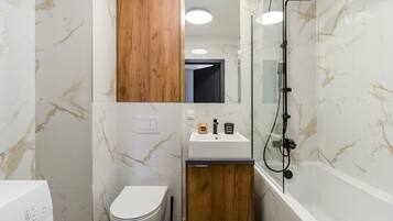 A bathroom with a toilet, sink, and shower.