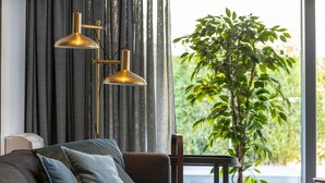 A modern living room with a sofa, a floor lamp, and a potted plant. - Villa Marli (Nin)