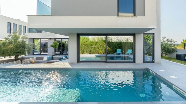 A modern house with a swimming pool, large glass doors, and a patio area. - Villa Marli (Nin)