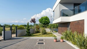 A modern building with a balcony, a paved courtyard, and a view of the sky. - Villa Marli (Nin)