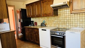 A kitchen with wooden cabinets, a white stove, and a tiled backsplash.